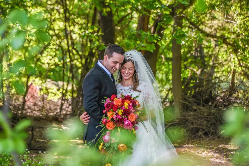 Novios con ramo en el bosque